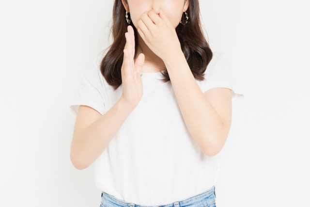 臭いで鼻をつまむ女性